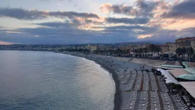 a beach with umbrellas and people on the beach at Very Nice Apartment in Nice
