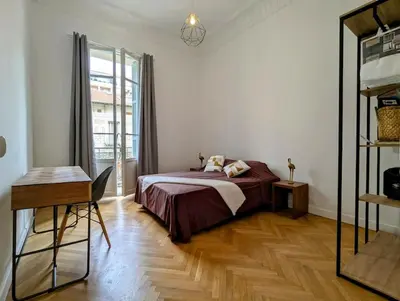 a bedroom with a bed and a desk and a window at 3 Pièces 70m2 Coeur de Nice in Nice