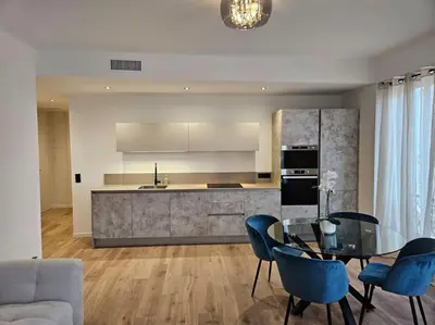 a kitchen with a glass table and blue chairs at Très bel appartement Nice centre in Nice