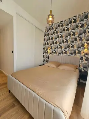 a bedroom with a large white bed with a wall at Très bel appartement Nice centre in Nice