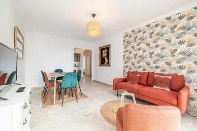 a living room with a red couch and a table at Large 2 Bdr Close to the Beach Balcony & Garage in Nice