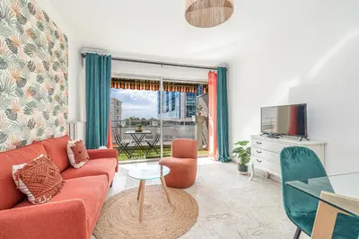 a living room with a red couch and a table at Large 2 Bdr Close to the Beach Balcony & Garage in Nice