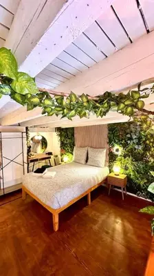 a bedroom with a bed with plants on the wall at Jungle avec Jaccuzi au coeur de Nice in Nice