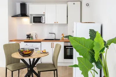 a kitchen with a table with a bowl of fruit on it at #58 Logement Clim & Balcon 5mins marche de la Mer in Nice