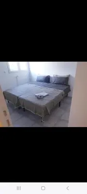 a bedroom with a bed with a blanket on it at Grand Appartement, 2 ou 3 ou 4 pieces, tramway sur place, proche gare sncf St Augustin 5 min, aéroport à 7 min, plage ou Allianz riviera 10 min, palais nikaia 2 min , supermarché sur place, parking possible si disponible ou payant à 1000 metre in Nice