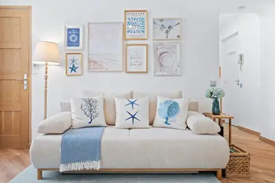 a living room with a couch with blue and white pillows at Nice Renting - 5bFRANCE - Luxurious Apartment Place Massena Promenade des Anglais in Nice