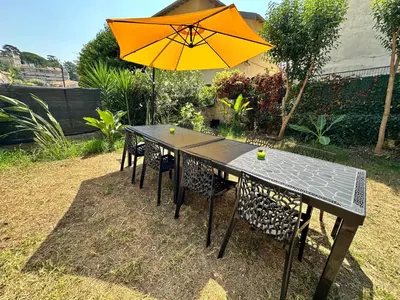 a table and chairs with an orange umbrella at Villa Lila in Nice