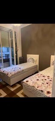two beds sitting in a room with a window at appartement 10mn à pied plage promenade in Nice