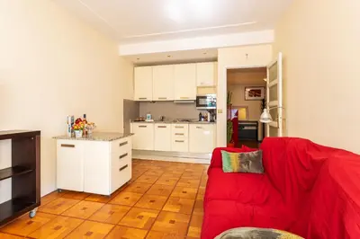 a living room with a red couch and a kitchen at LE CAPITOL 2 AP4421 By Riviera Holiday Homes in Nice