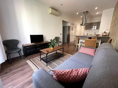a living room with a couch and a kitchen at Appart T3 Clim Hypercentre in Nice