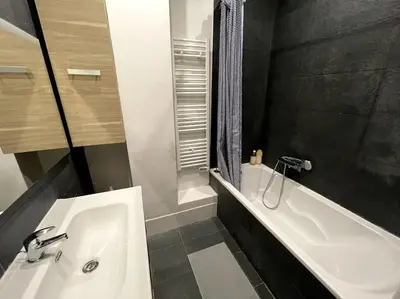 a bathroom with a white sink and a bath tub at Appart T3 Clim Hypercentre in Nice