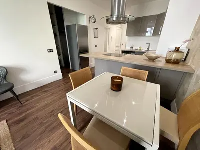 a kitchen with a white table and chairs and a counter at Appart T3 Clim Hypercentre in Nice