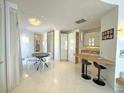 a kitchen with a table and chairs in a room at Sea Front Penthouse Cote d Azur in Nice