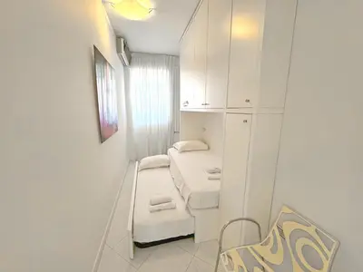 a small white room with two beds in it at Sea Front Penthouse Cote d Azur in Nice
