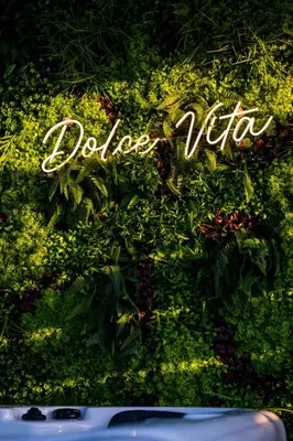 a sign that says dolce vita on a wall with plants at Dolce Vita, Spa, Cagnes Sur Mer in Cagnes-sur-Mer