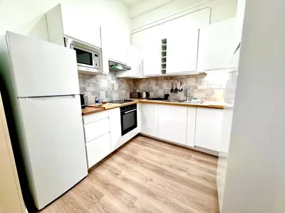 a white kitchen with white cabinets and a sink at ApartHotel Riviera - COCON DU MOULIN - Old Town Promenade des Anglais in Nice