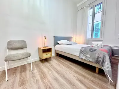 a white kitchen with white appliances and wooden floors at ApartHotel Riviera - COCON DU MOULIN - Old Town Promenade des Anglais in Nice