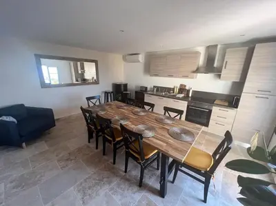 a living room with a black couch and a table at Entre les citronniers et la mer in Èze
