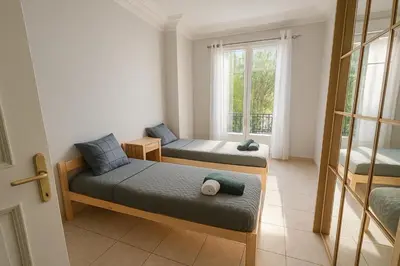 a room with two beds and a window at Spacieux appartement climatisé centre Nice in Nice