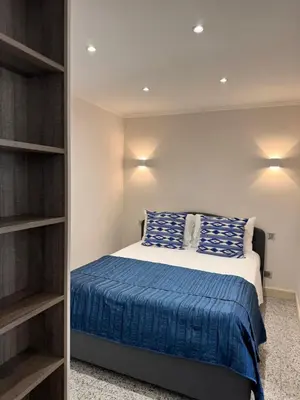 a bedroom with a bed and a book shelf at Mala Beach Sea View in Cap d'Ail