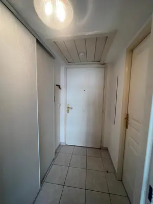 a hallway with a white door and a tile floor at La Terrasse de Palais des Arts in Nice
