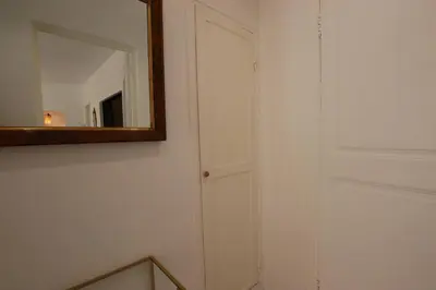 a mirror on a wall next to a white door at Appartement de charme centre vieux village in Villefranche-sur-Mer