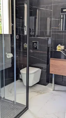 a bathroom with a toilet and a glass shower at Olive Grove Retreat in La Trinité