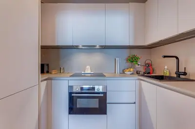 a kitchen with white cabinets and a sink and a stove at LE 3 PROMENADE AP4424 By Riviera Holiday Homes in Nice