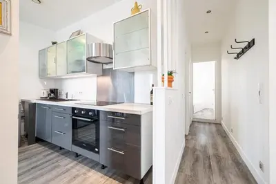 a kitchen with stainless steel appliances and wood floors at MY CASA - OLIVETTO - Superb city center apartment with AC in Nice
