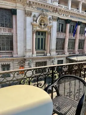 a table and a chair on a balcony with a building at Vera Nizza in Nice
