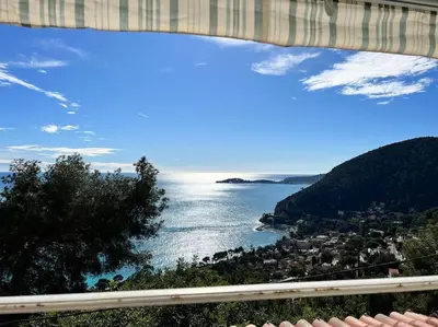 a living room with a wooden table and chairs at Entre les citronniers et la mer in Èze