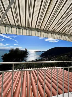 a view of a town on a hill next to the water at Entre les citronniers et la mer in Èze