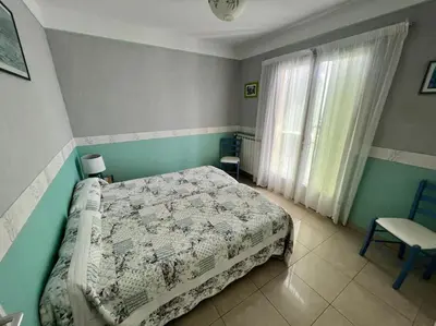 a bedroom with a bed and a chair and a window at Entre les citronniers et la mer in Èze
