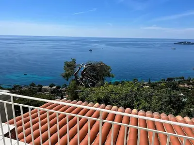 a blue and white bathroom with a toilet and a sink at Entre les citronniers et la mer in Èze
