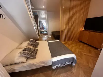 a bedroom with a bed with pillows and a television at Studio moderne climatisé avec coin nuit, proche mer et Hauts de Cagnes in Cagnes-sur-Mer
