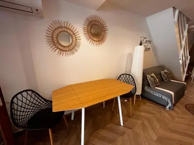 a living room with a table and two mirrors on the wall at Studio moderne climatisé avec coin nuit, proche mer et Hauts de Cagnes in Cagnes-sur-Mer