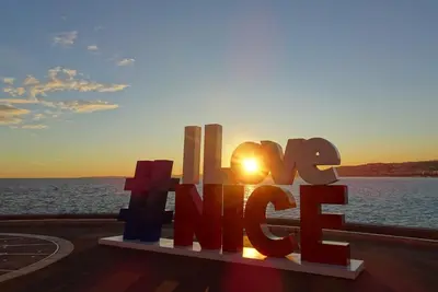 a sign that says happy in front of the ocean at 