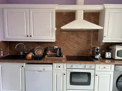 a kitchen with white cabinets and a sink at Le Dante CLIM Balcon in Nice