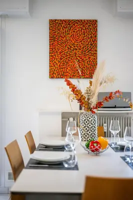 a dining room table with a vase and a bowl of fruit at Ciel d'Orves - Terrasse Spacieuse- Parking privé in Nice
