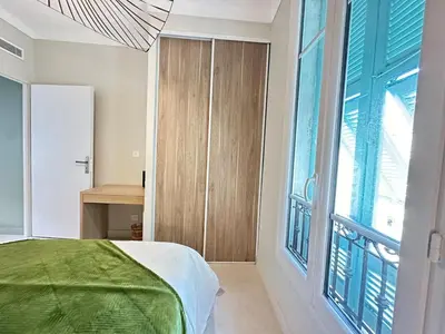 a bedroom with a bed and a large window at 3P neuf et climatisé Nice le Port à 9mn de la mer in Nice
