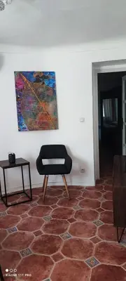 a room with a chair and a painting on the wall at Villa CALIFORNIA in Nice