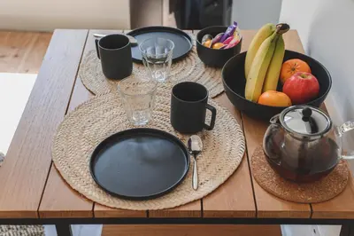 a wooden table with plates and bowls of fruit on it at Bohème-Chic au cœur du VIEUX NICE #Lovely in Nice