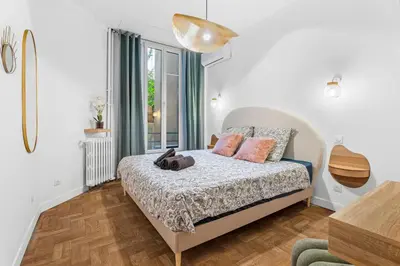 a white bedroom with a bed and a window at Nice Renting - VERDI - Apartment Charm & Comfort & AirCon in Nice
