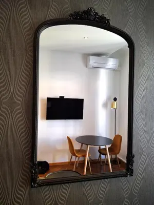a mirror reflecting a table and chairs in a room at Superbe Appartement au Cœur de Nice in Nice