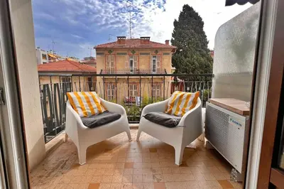 a balcony with two chairs and a building at Le Villermont - Liberation Centre Ville in Nice