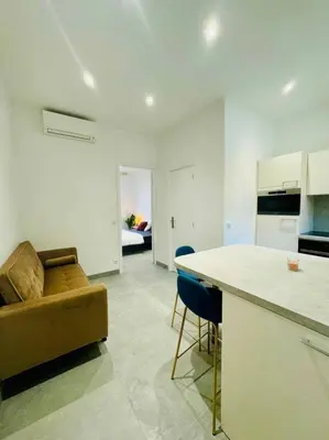 a kitchen and living room with a couch and a table at LEî in Beaulieu-sur-Mer