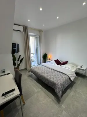 a bedroom with a large bed and a desk at LEî in Beaulieu-sur-Mer