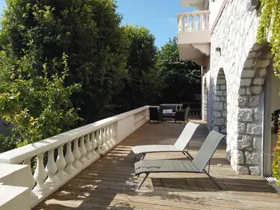 a pair of chairs sitting on a wooden deck at Villa spacieuse, totalement adaptée aux normes PMR in Nice