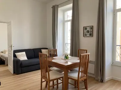 a living room with a table and chairs and a couch at LocaNice Masséna in Nice