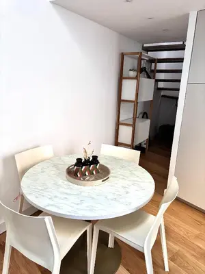 a white dining room with a round table and white chairs at Duplex moderne port de Nice in Nice